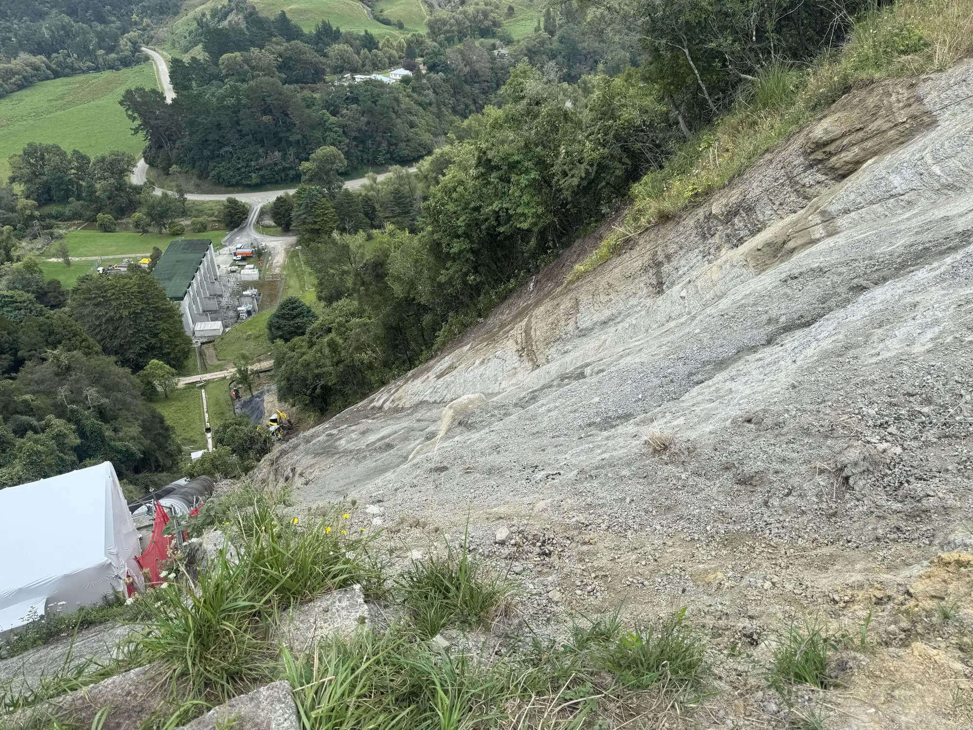 Steep bush-clad slope with exposed weathered rock